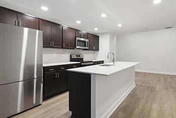 a kitchen with a white counter top and a stainless steel refrigerator